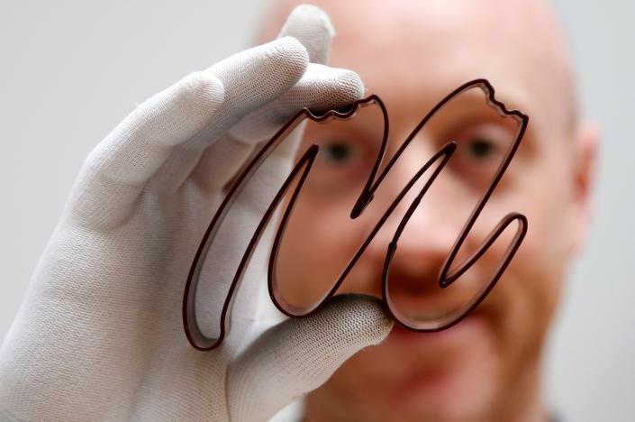 Gaetan Richard poses with the logo of the Miam Factory 3D printing chocolate company after being printed by a specialized 3D machine in Gembloux, Belgium, April 10, 2017. Picture taken April 10, 2017. REUTERS/Francois Lenoir